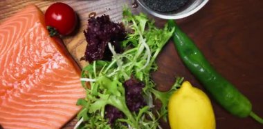 Renkli sebzelerle taze çiğ somon bifteği ve ahşap bir tahta üzerinde aromatik baharatlar. Sağlıklı yemek, yemek ve deniz ürünleri kavramları için idealdir..