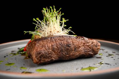 Kızarmış sebze ve aromalı sosla servis edilen sulu ızgara biftek. Restoran menüleri, yemek kitapları, reklamlar ve yemek dağıtım hizmetleri için çok kaliteli bir sunum..