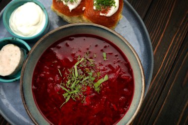 Geleneksel Ukrayna çorbası ekşi krema ve sarımsaklı pampuşki ekmeğiyle servis edilir..