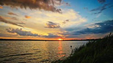 Göl üzerinde yağmurdan sonra sersemletici bir gün batımı, doğa ve seyahat görselleri için dramatik gökyüzü