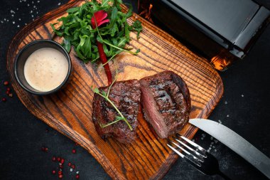 Juicy meat steak cut in half on wooden board, gourmet beef meal for food photography