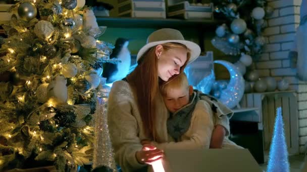 魅力的な男の子の子供と10代の女の子は 新年2023ギフト 驚きと幸せな感情を開きます ライトアップされたクリスマスツリーの近くで楽しく明るい白人の子供たち 高品質4K映像 — ストック動画