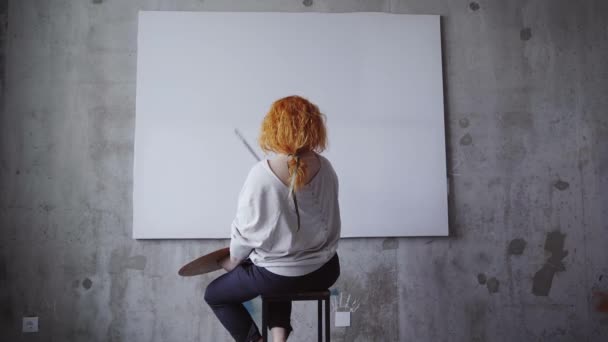 Αξιολάτρευτη Καλλιτέχνης Κοκκινομάλλα Γυναίκα Κάθεται Μπροστά Από Λευκό Λευκό Λευκό — Αρχείο Βίντεο