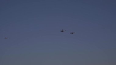 Askeri helikopterler peş peşe uçuyor. Hava Kuvvetleri geçit töreni. Açık mavi gökyüzünde askeri helikopterler. Yüksek kalite 4k video kaydı