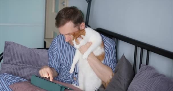 Ελκυστικός Γενειοφόρος Άνδρας Χρησιμοποιώντας Tablet Υπολογιστή Κάθεται Στο Κρεβάτι Νυχτικά — Αρχείο Βίντεο