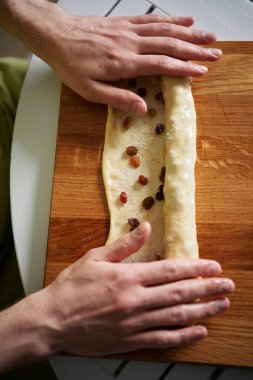 Ev kavramında Paskalya pastası kabuğu hazırlama. Yoğurt hamuru katlayıp tereyağına bulayan tanınmamış bir insan. Yüksek kaliteli resim