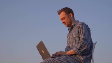 Kazanmak, şok etmek, şaşırmak ya da zafer duygusu konsepti. Sakallı beyaz erkek serbest çalışan arka planda açık mavi gökyüzü olan pijamalar giyen. Yüksek kalite 4k görüntü