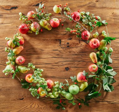 Elmalar yuvarlak kompozisyon olarak ahşap bir masada. Hasat mevsimi. Sulu kırmızı ve yeşil elmaların üst görüntüsü. Organik ürünler hasat ediyorum. Yüksek kaliteli resim
