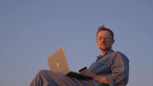 在户外用笔记本电脑上网购买眼镜和睡衣的有吸引力的男性 白种人指指点点相机 同意手势 优质4K视频 — 图库视频影像