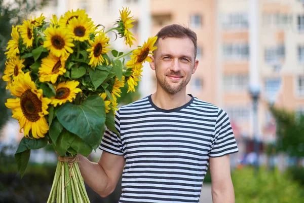 一束黄色的向日葵握在一个微笑的快乐男人的手中 充满爱心和感恩的爱国礼物母亲节 支持乌克兰 独立日 高质量的照片 — 图库照片