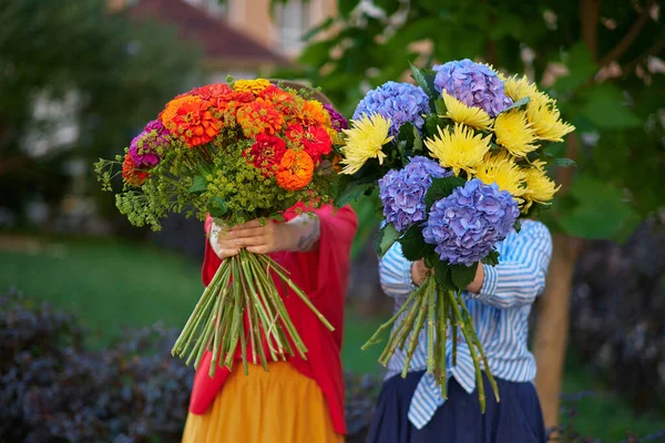 Two Women Holding Bouquet Blue Orange Yellow Flowers Background Green — Stock Photo, Image