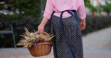 Bir sepet kurumuş çiçekli önlüklü bir çiftlik kadını, köy hayatı. Lavanta demetli çiçekçi kadın. 4k görüntü