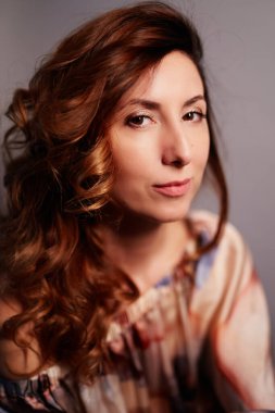 Gri arkaplandaki kameraya gülümseyen orta yaşlı doğal görünümlü kadınlar. Yüksek kaliteli dikey fotoğraf