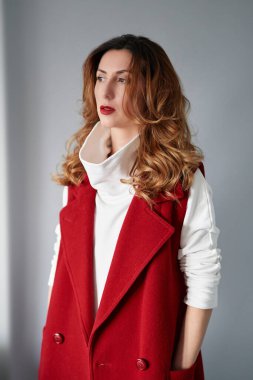 Stüdyo portresi dalgalı saçlı, kahverengi gözlü, zarif bir kestane rengi takım elbiseli, bir şeyler düşünüp hayal eden muhteşem bir esmer. Yüksek kaliteli dikey fotoğraf