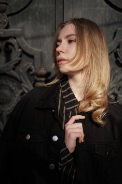 Genç hippi ya da model portresi. Yakından kendine güveni tam, beyaz görünümlü, sarışın, ilginç ışık ve günlük kıyafetlerle şehirde dikilen genç bir kız. Yüksek kalite fotoğraf