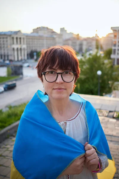 Běloška Bílé Blůze Brýlích Zakrytých Vlajkou Ukrajiny Proti Výhledu Město — Stock fotografie