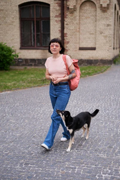 Sırt Çantalı Güzel Bir Kadın Eski Şehir Manzarasında Köpekle Yürüyor — Stok fotoğraf