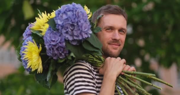 Mężczyzna Uśmiecha Się Trzymając Bukiet Hortensji Żółte Kwiaty Patrząc Kamerę — Wideo stockowe