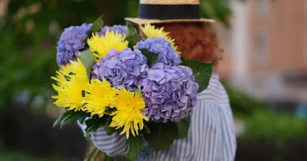 緑の庭春のコンセプトを背景に青いアジサイの花束を持っている女性 高品質の写真4K映像 — ストック動画
