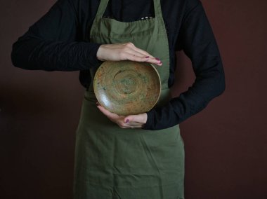 Önlüklü genç bir kadın, elinde yuvarlak bir kaplama, klasik aile kavramı. Gösterişsiz kusurlu fotoğraf. Yüksek kalite fotoğraf