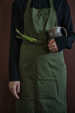Önlüklü genç bir kadın elinde ekmek ve çömlekçilik, klasik akrabalık kavramı. Gösterişsiz kusurlu fotoğraf. Yüksek kalite fotoğraf