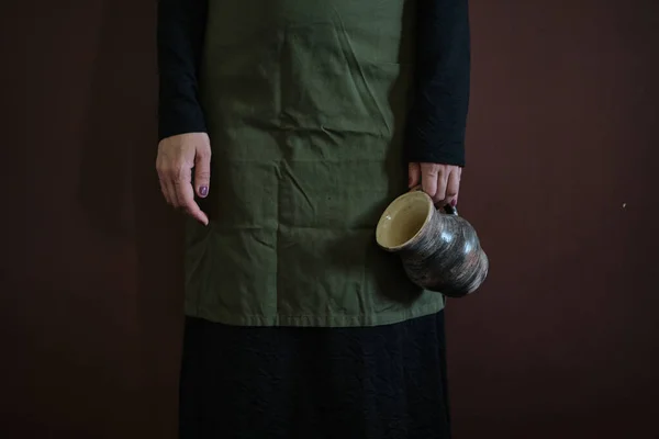 パンと陶器を持ったエプロンの若い女性ヴィンテージ キンフォークのコンセプト 低キー不完全写真 高品質の写真 — ストック写真