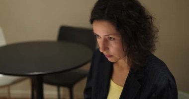 Ofiste konuşan ve masada oturup kahve içen iki bayan meslektaşım. Bir kadın bir şeyi jestle açıklıyor. Yüksek kalite 4k görüntü