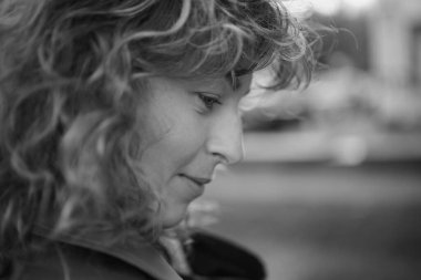 Kameraya bakan mutlu olgun bir kadının portresi. Gün batımında şehir sokağında başarılı bir gururlu kadın. Açık havada gülümseyen resmi giysili beyaz kadın. Yüksek kalite fotoğraf