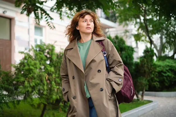 Kameraya bakan mutlu olgun bir kadının portresi. Gün batımında şehir sokağında başarılı bir gururlu kadın. Açık havada gülümseyen resmi giysili beyaz kadın. Yüksek kalite fotoğraf