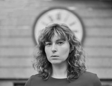 Zaman kavramına dikkat et. Koyu kırmızı elbiseli, başında kocaman bir saat olan bir kadın. Genç esmer kadın saate bakıyor. Zamanı takip et. Yüksek kalite fotoğraf