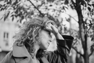 Beyaz, olgun, güzel bir kadının yakın plan portresi. Parkta güneşe bakıyor. Gün batımından saklanıyor. Yüksek kalite fotoğraf