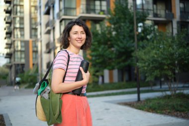 Yaz güneşli bir hayat tarzı, şık bir hipster kadının sokakta yürüdüğü, şık kıyafetler giydiği, gülümsediği, hafta sonlarının keyfini çıkardığı, çantasıyla seyahat ettiği bir resim. Yüksek kalite fotoğraf