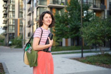 Yaz güneşli bir hayat tarzı, şık bir hipster kadının sokakta yürüdüğü, şık kıyafetler giydiği, gülümsediği, hafta sonlarının keyfini çıkardığı, çantasıyla seyahat ettiği bir resim. Yüksek kalite fotoğraf