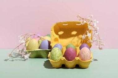 Multi colored eggs in colored boxes with flowers