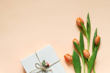 Pastel colored composition of orange tulips and decorated box