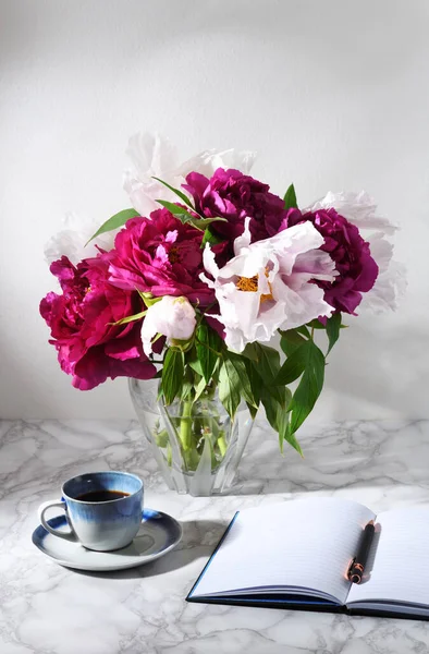 コーヒーとノートのカップと美しい牡丹の花束 — ストック写真