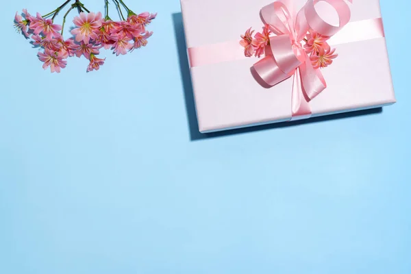 粉红装饰盒和蓝色花朵的背景 — 图库照片