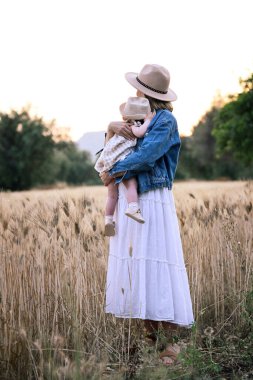 Gün batımında küçük kızıyla birlikte bir kadın