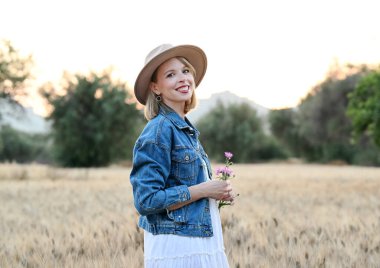 Gün batımında dışarıda poz veren güzel bir kadın.