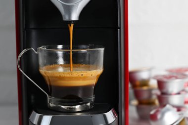 Espresso makinesi cam bardakta kahve yapıyor.
