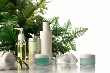 Palmiye yaprakları arka planında vücut bakım ürünlerinin düzenlenmesi