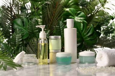 Palmiye yaprakları arka planında vücut bakım ürünlerinin düzenlenmesi