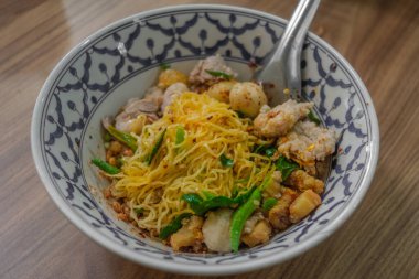 Sukothai usulü Tayland Tom-Yum çorbası. Arkaplan olarak ahşap tablo ile üst görünüm.