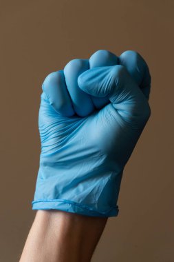 Parlak mavi bir eldiven giyen biri tanınmış bir barış yapıyor. 