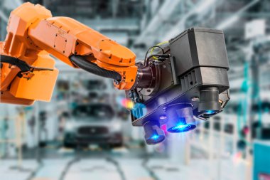 Otomobil imalat fabrikasının arka planında 3 boyutlu lazer tarayıcı var. Otomotiv teknolojilerinin geliştirilmesi ve üretimi. Otomatik robot kolu montaj hattı üretimi.