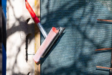 Bir makas ve bir fırça şu anda rahat bir şekilde duvarın üzerinde dinleniyor, yan yana konulmuş, tesadüfi bir şekilde.