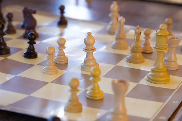 Bu çok güzel hazırlanmış bir satranç tahtasının detaylı bir görüntüsü. Üzerinde çeşitli satranç taşları zarif bir şekilde yerleştirilmiş.