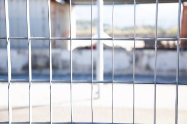 Bu resim, odaklanmasını ve detaylarını arttıran bulanık bir arkaplanı olan sağlam metal bir çitin yakın görüntüsünü içeriyor.