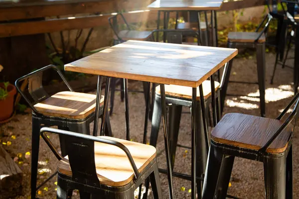 Dışarıda güzel bir sıra masa ve sandalye var. Güneşin tadını çıkarıyorlar. Güneşli bir günde.