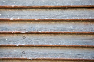 Bu ilginç bir yakın çekim görüntüsü. Bir bina veya yapıya sabitlenmiş ahşap bir kepenk detaylarını gösteriyor.